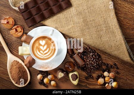 cup of delicious latte with chocolate and roasted coffee beans covered in burlap Stock Photo