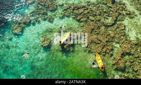 Tourists on the kayak in the lagoon with clear water, aerial view. Snorkeling and kayaking in the lagoon. Small lagoon with turquoise water. El nido, Philippines, Palawan. Summer and travel vacation concept. Stock Photo