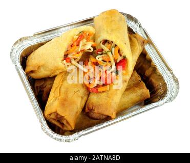 Chinese crispy vegetable filled spring rolls in an aluminium foil take away tray isolated on a white background Stock Photo