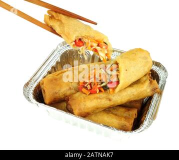 Chinese crispy vegetable filled spring rolls in an aluminium foil take away tray isolated on a white background Stock Photo