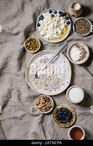 Healthy breakfast. Variety of breakfast dishes sprouted wheat, yogurt, kefir, cottage cheese, seeds, nuts and berries assortment in ceramic bowls. Lin Stock Photo
