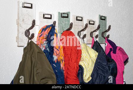 Colorful clothing, coats, jacket on wooden coat hook – cold winter season Stock Photo