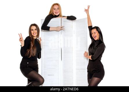 three young female friends pose together in the Studio. three friends pose and joke. isolated background Stock Photo