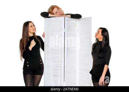 three young female friends pose together in the Studio. three friends pose and joke. isolated background Stock Photo
