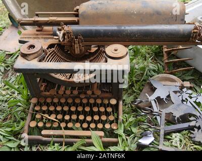 Rusty old typewriter on the ground for sale at a flea market Stock Photo