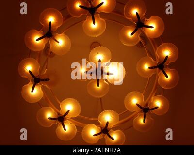 Upward shot of lighted bulbs in floral designs mounted on the ceiling Stock Photo