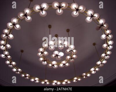 Upward shot of light bulbs in circular designs mounted on the ceiling Stock Photo