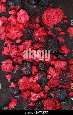Dark dark chocolate bar with dried berries close-up, view from above, selective focus Stock Photo