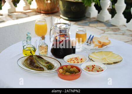 A selection of tapas with a jug of Sangria, beer and orange juice, Fried pointed green peppers, Green olive cocktail, Cubed Manchego cheese. Stock Photo