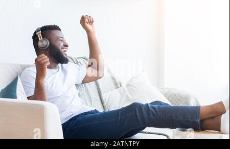 Active black man dancing, listening to music at home Stock Photo