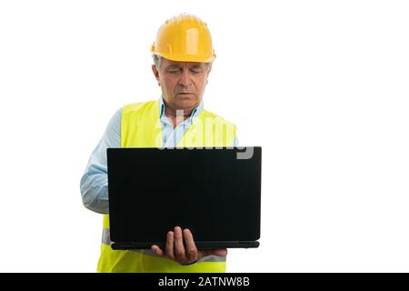 Old engineer man with serious expression looking at personal computer or laptop isolated on white background Stock Photo