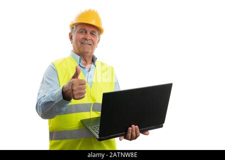 Old architect man holding laptop and making like gesture with thumb up and friendly expression isolated on white background Stock Photo