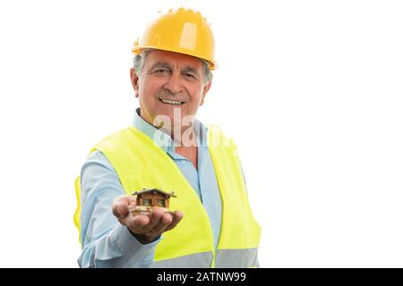 Old engineer with friendly smile presenting small wooden house as building concept isolated on white background Stock Photo