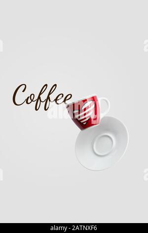 Coffee text spilled out red cup with heart levitation in the air on grey background, holiday layout for your design, copy space, closeup, love cafe cr Stock Photo