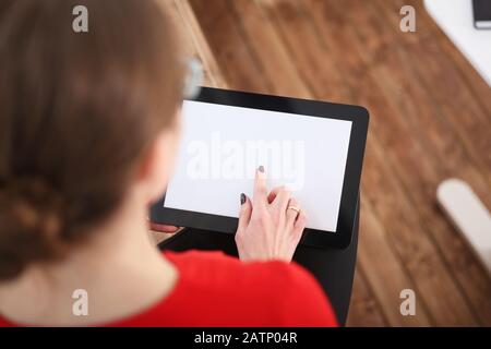 Woman holding tablet in hands. He presses his finger on the display Stock Photo