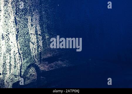 Raindrops and stains on glass at night in the city, background Stock Photo