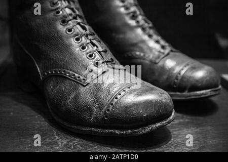 Old used shoes made of genuine leather, close up photo with selective focus. Black and white Stock Photo