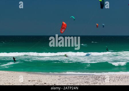 Kitesurfers enjoy their sport at the famous kiting beach at Haakgat Point, Otto du Plessis Drive, Melkbosstrand, Table Bay, Capte Town, South Africa Stock Photo
