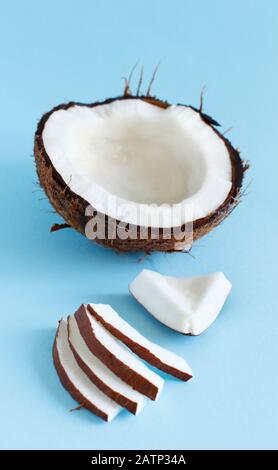 Coconut pieces on a light blue background close up Stock Photo
