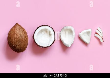 Ehole coconut and coconut pieces on a light pink background top view Stock Photo