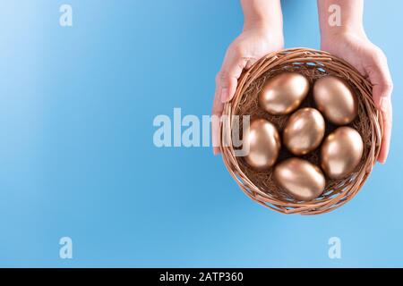 Hands holding golden eggs in the nest. Easter concept or Retirement planning concept. Stock Photo