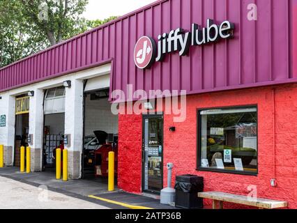 Deer Park, New York, USA - 12 June 2019: Three bay doors are open nest to the waiting room of a jiffy lube oil change building. Stock Photo
