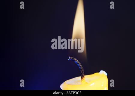 Yellow candle with smoke and flame photographed in the studio with color foils before the flashes Stock Photo