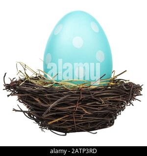 Blue dyed big easter egg in a bird nest isolated on a white background Stock Photo