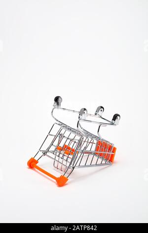 Overturned shopping cart on white background. Concept of economic depression or inflation or dropping purchasing power. Stock Photo