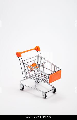 Empty shopping cart trolley on white background with copy space. Close up. Stock Photo