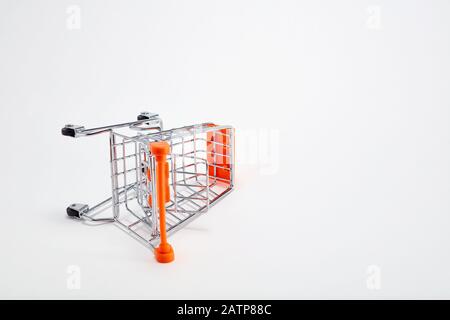 Overturned shopping cart on white background. Concept of economic depression or inflation or dropping purchasing power. Stock Photo