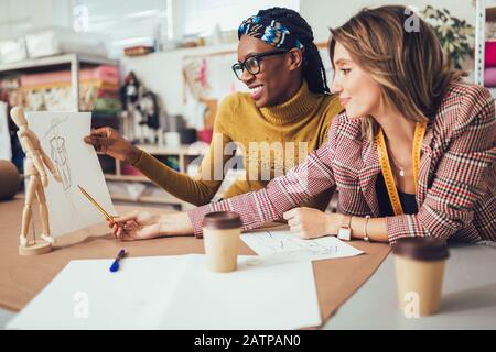 Two young entrepreneur women, or fashion designers working in atelier Stock Photo