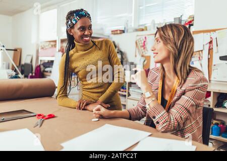 Two young entrepreneur women, or fashion designers working in atelier Stock Photo