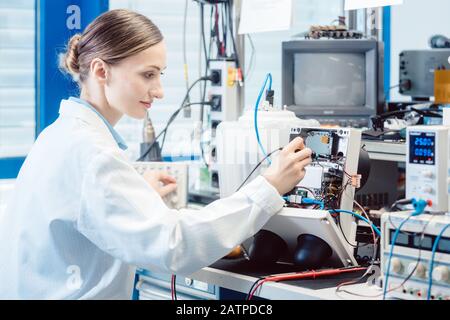 Engineer woman measuring electronic product on test bench Stock Photo