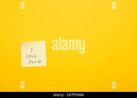 one sticky note on yellow background saying I love you Stock Photo