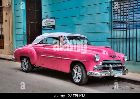 Pink classic old car parking on a street in Old Town; Havana, Cuba Stock Photo
