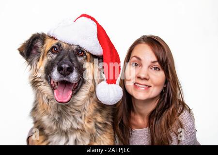 A Christmas portrait of a woman and her dog on a white background; Studio Stock Photo
