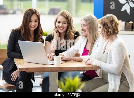 A group of business woman being trained by their team leader in a coffee shop at a place of business: Edmonton, Alberta, Canada Stock Photo
