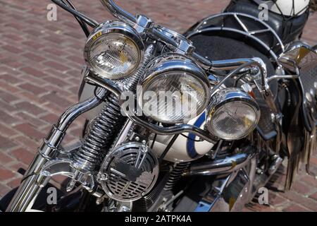 A motorcycle full of chrome elements, chopper type. Front view of a motorcycle lamp. Stock Photo