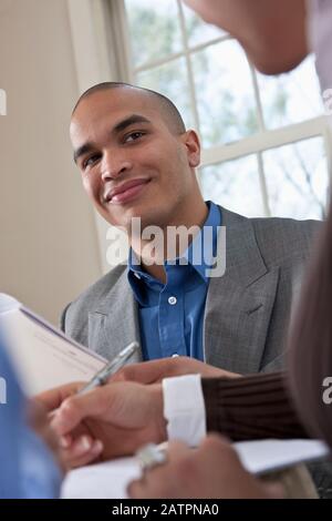 Young professionals working together at a table reviewing documents Stock Photo