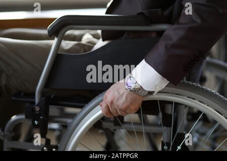Disability businessman with wheelchair against business office Stock Photo