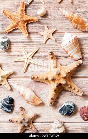 Starfish and seashells background on a wooden table, top view, flat lay. Stock Photo