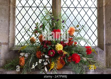 flower display for harvest festival in St Mary's church, Bibury, Gloucestershire Stock Photo