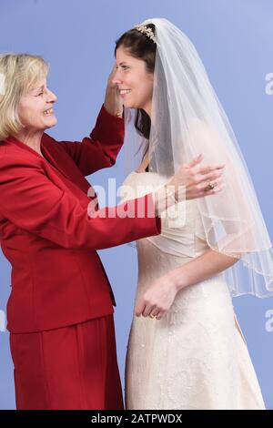 Side view of smiling bride and her mother. Stock Photo