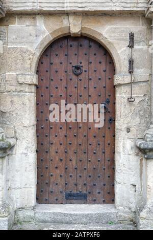 wooden studded door with brass draw bell, Cotswolds England Stock Photo