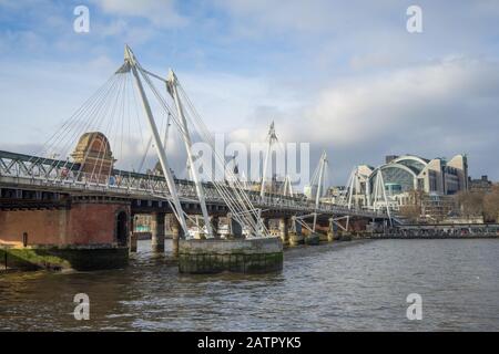 The Hungerford Bridge and Golden Jubilee Bridges over the River Thames in London, with Charing Cross Road Station in the distance. Stock Photo