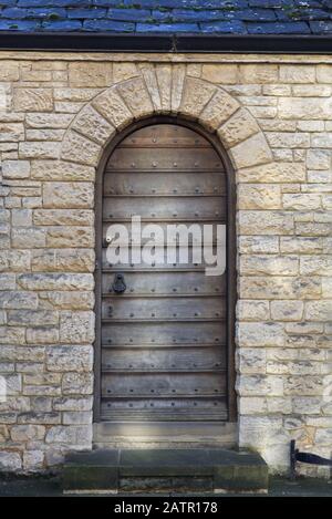 wooden door and arched stone building Stock Photo