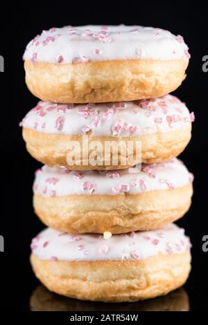 White Chocolate Donuts or Doughnuts Tower on Dark Background . Stock Photo