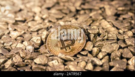 Golden Bitcoin Coin on a pile of Gold nuggets. Blockchain cryptocurrency, store of value. Digital gold concept. Stock Photo