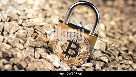 Bitcoin blockchain security concept with key lock on gold pile background Stock Photo